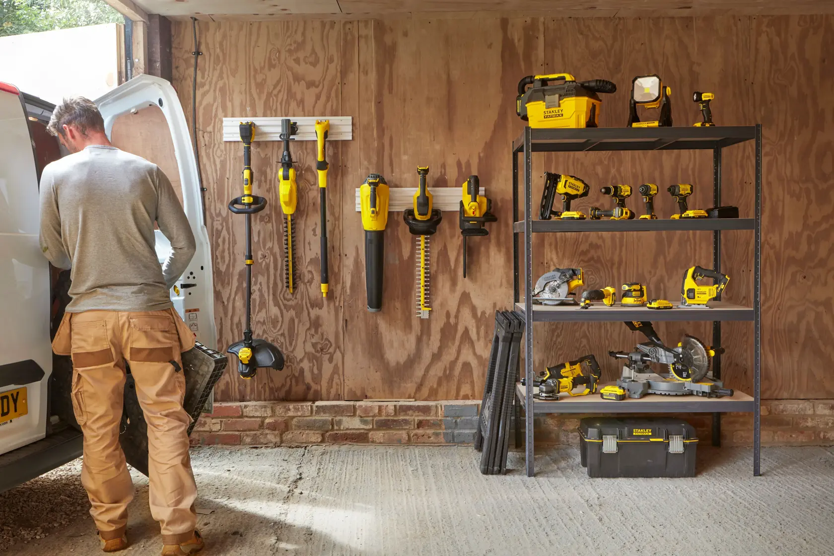 STANLEY SFMCPS620B power tools and accessories organized in a garage, shelving and wall storage visible.