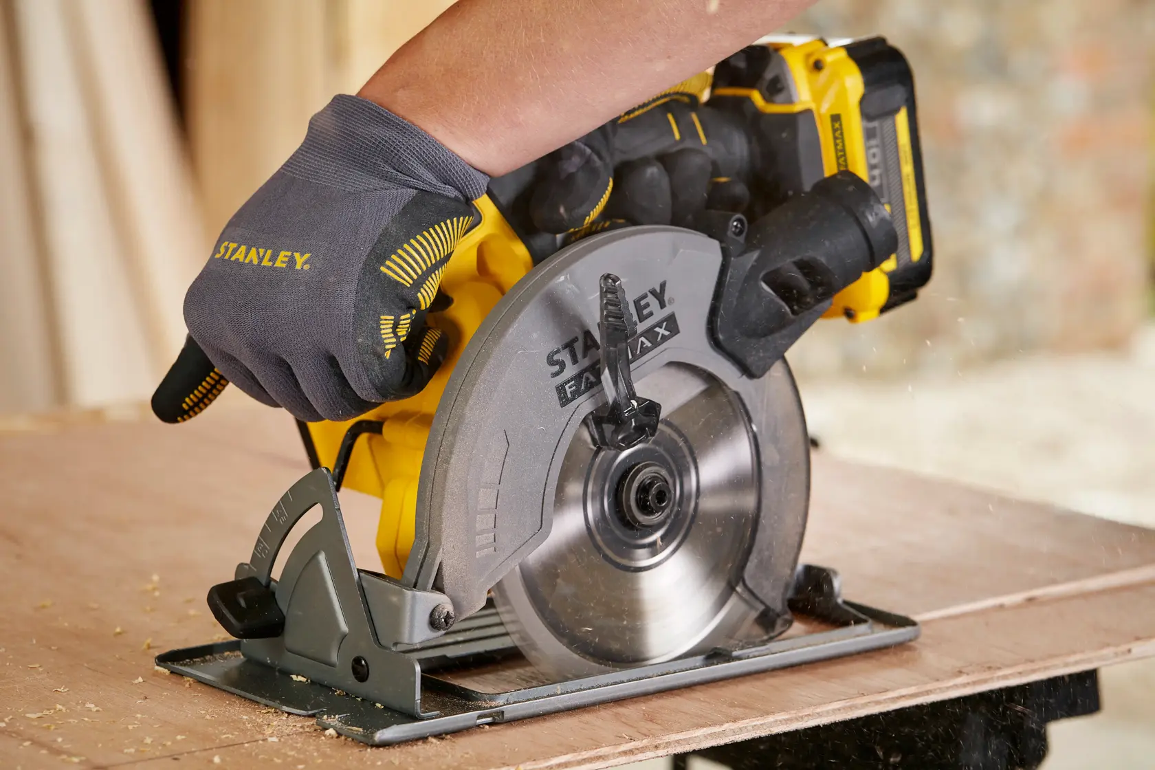 STANLEY SFMCS500M2K photography of cordless circular saw cutting wood, close side angle.