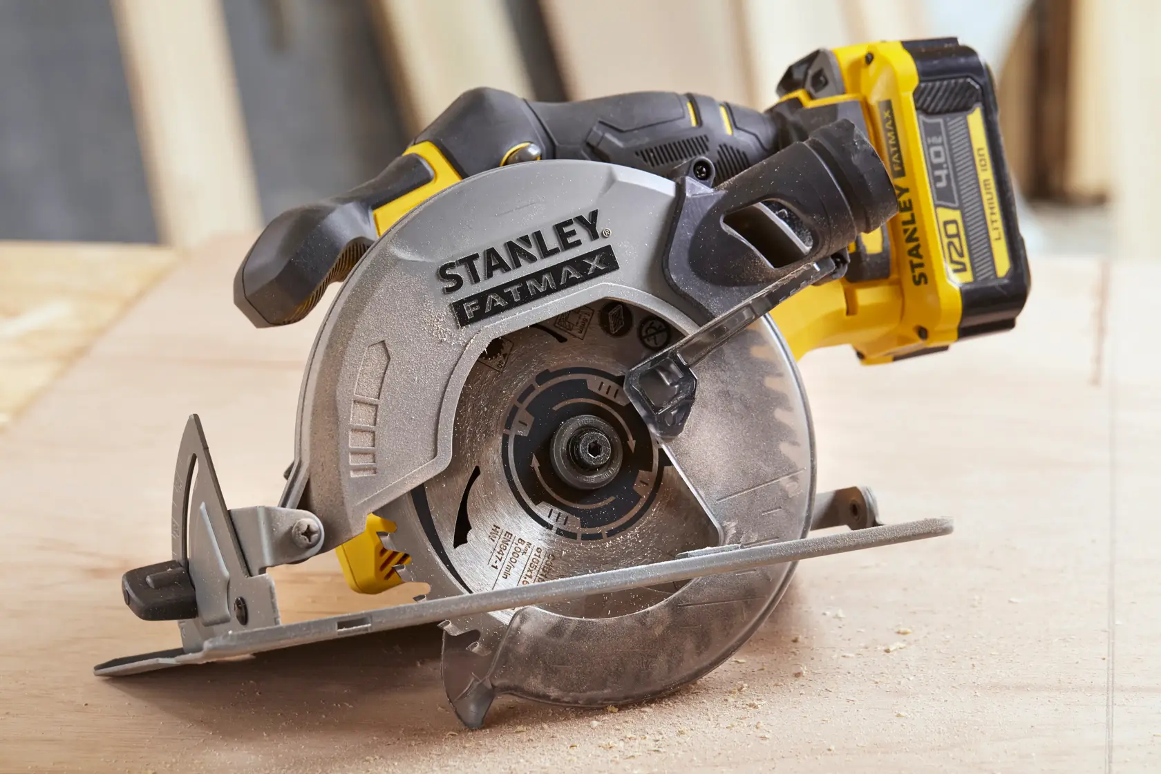 STANLEY SFMCS500M2K cordless circular saw, side angle, with blade cutting wood surface.