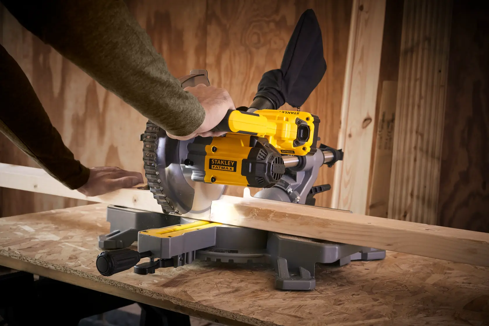 STANLEY SFMCS701M1 miter saw in use cutting wood, workshop setting, side angle.