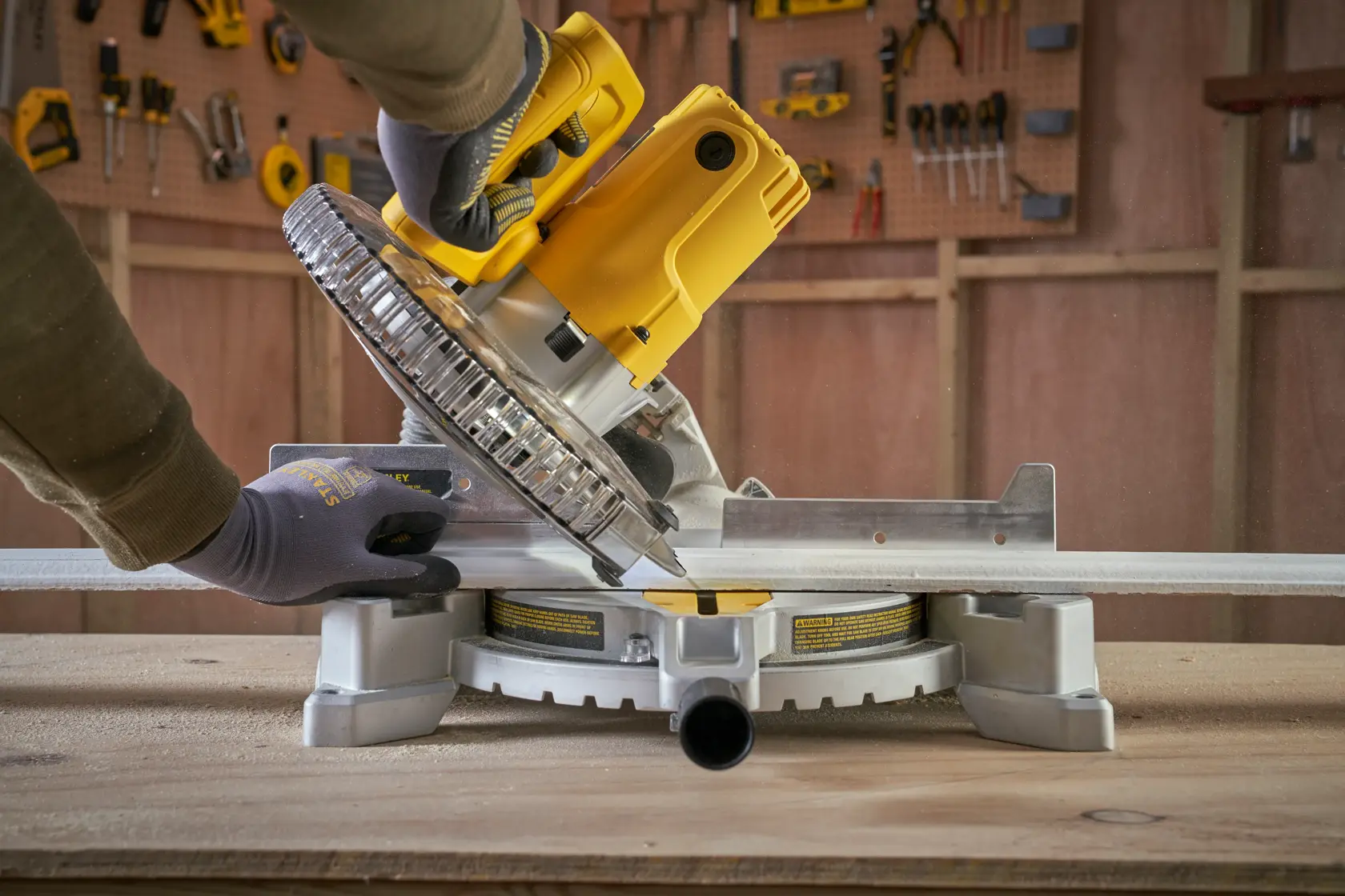 STANLEY SM1650 miter saw being used to cut metal, shown from side angle in workshop.