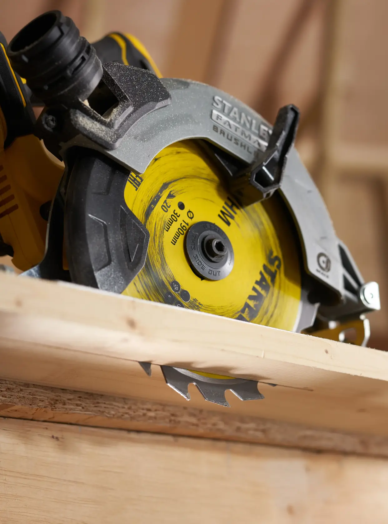 STANLEY STA13030 circular saw close-up cutting wood, showing yellow and black blade and guard.