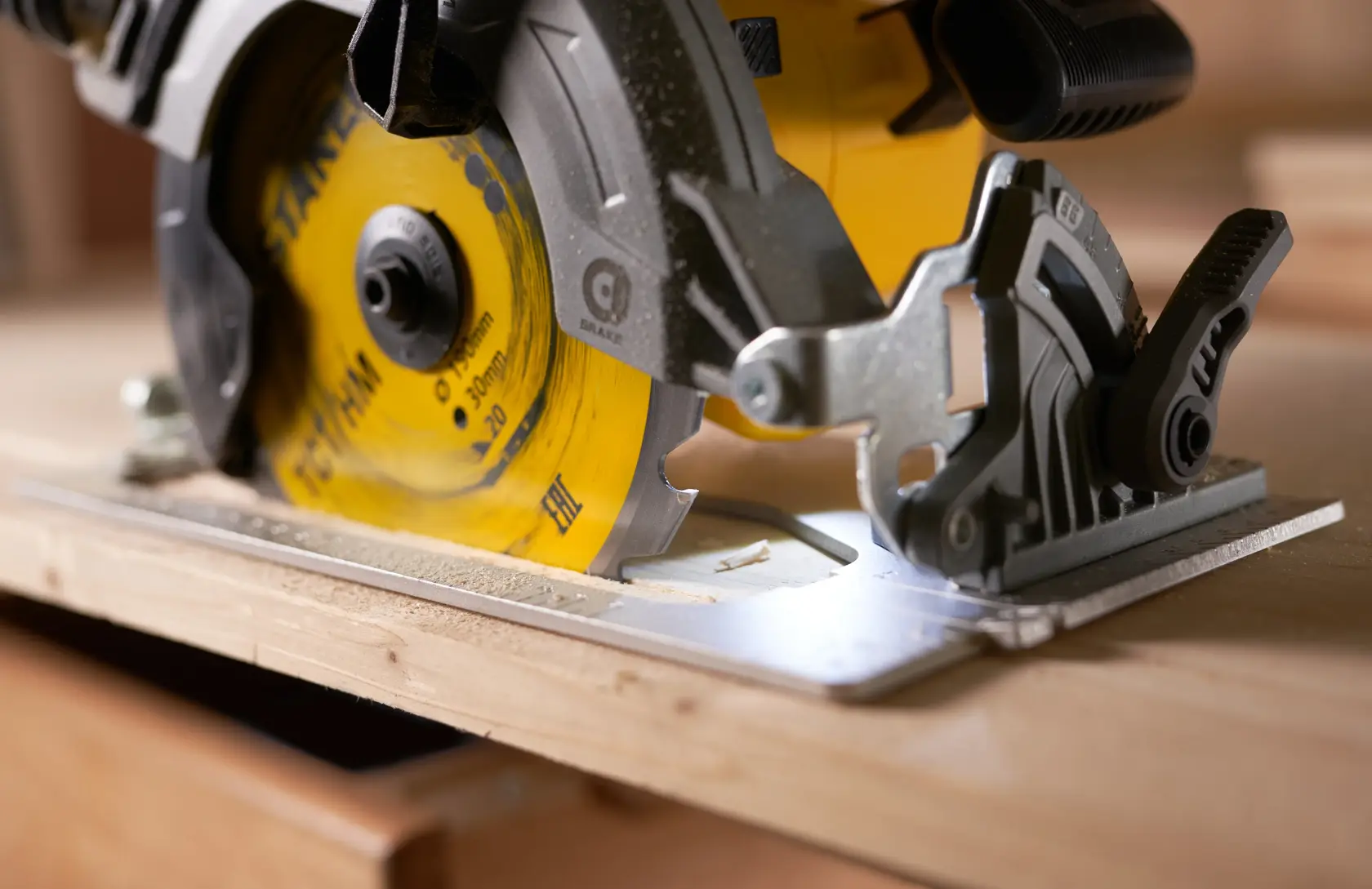 STANLEY STA13030 circular saw close-up cutting wood, yellow blade, photography.