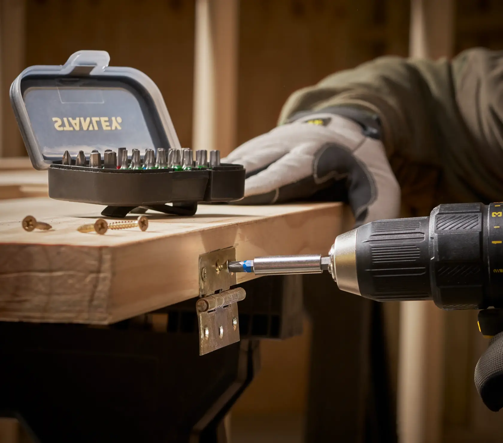 STANLEY STA60490 bit set in open case on table, with drill attaching hinge to wood.