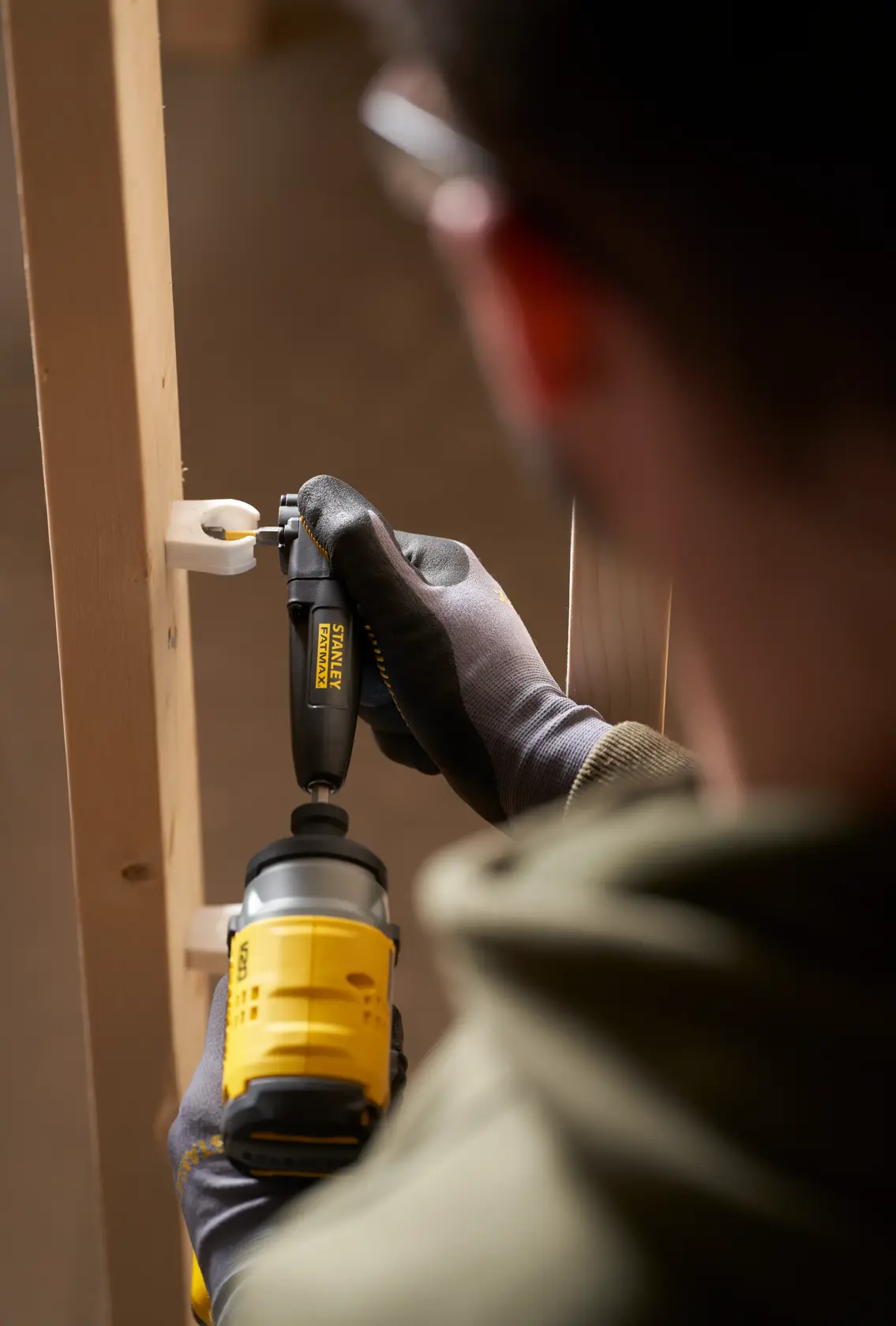Photo of STANLEY STA88582-XJ right angle drill attachment used on a wooden frame, close-up view.