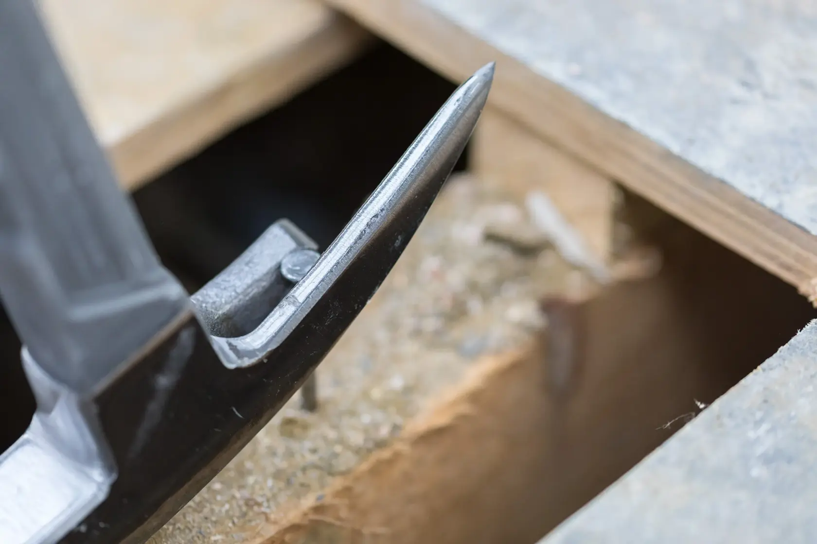 Close-up photo of STANLEY STHT0-51312 claw hammer head prying near wood, product photography.