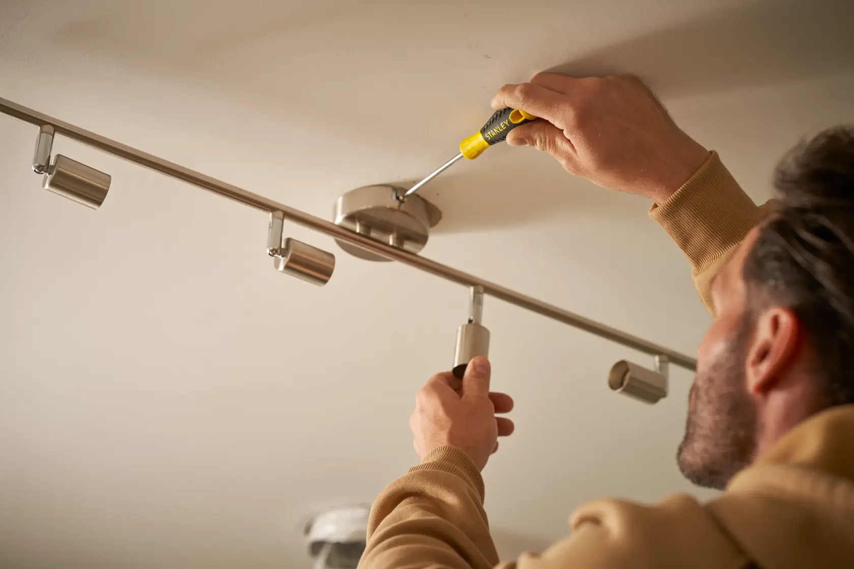 STANLEY STHT0-60276 screwdriver used to install ceiling light fixture, product in hand, close-up.
