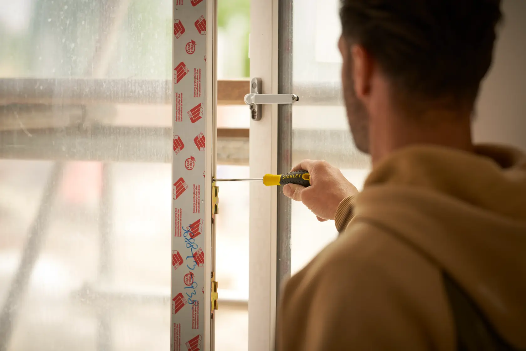 STANLEY STHT0-60335 screwdriver used to install window lock, close-up indoor photography.