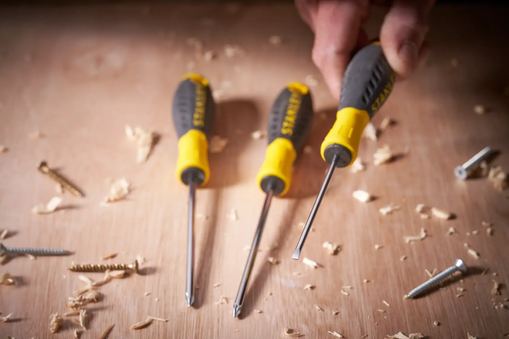 Photo of STANLEY STHT0-60358 screwdriver set with yellow and black handles on a wooden surface with screws.
