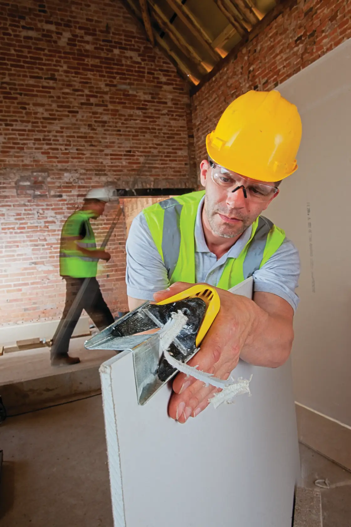 STANLEY STHT1-05937 hand tool for cutting drywall, shown in use on construction site.