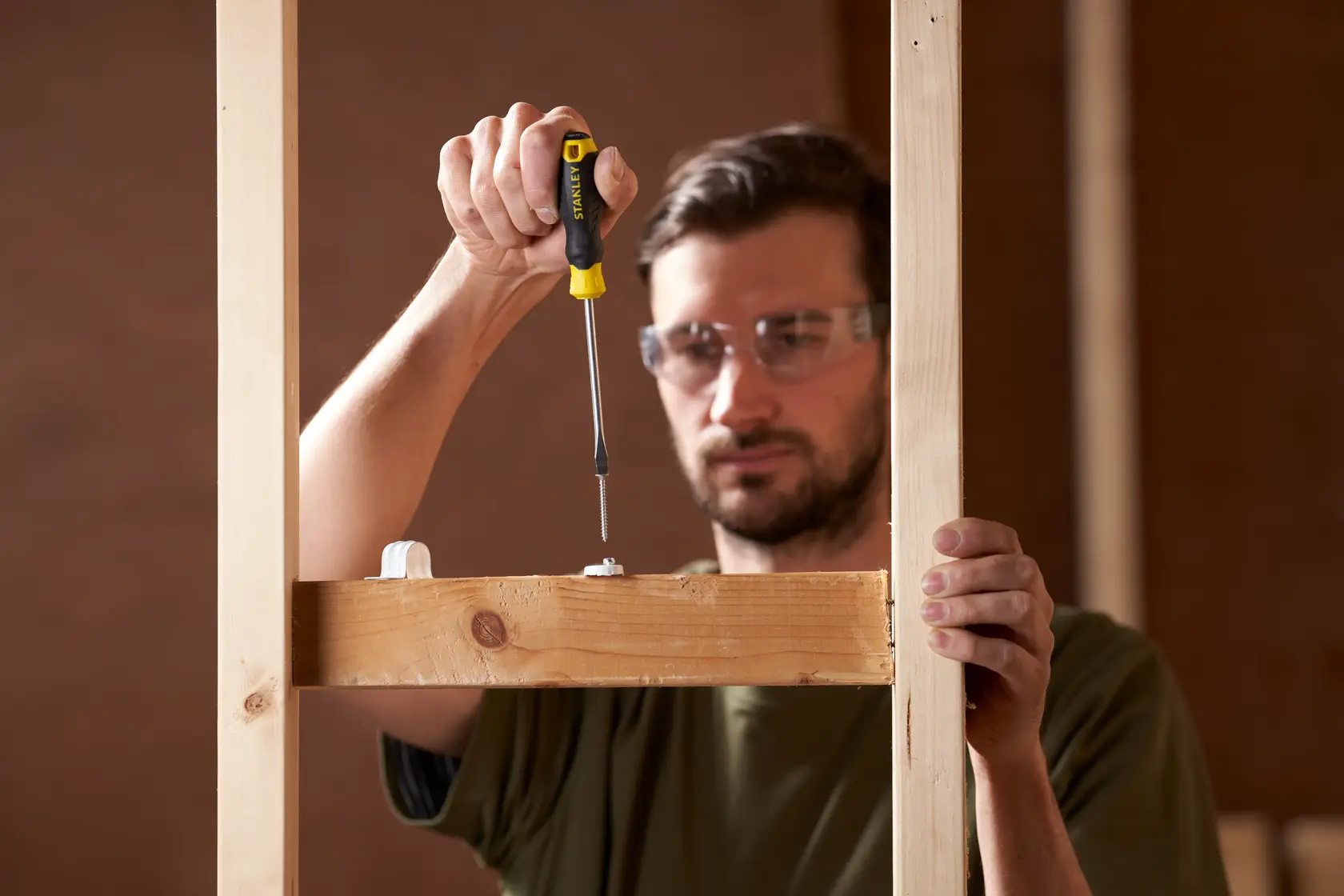 Photo of STANLEY STHT16146-0 screwdriver used to fasten screw into wood during construction.