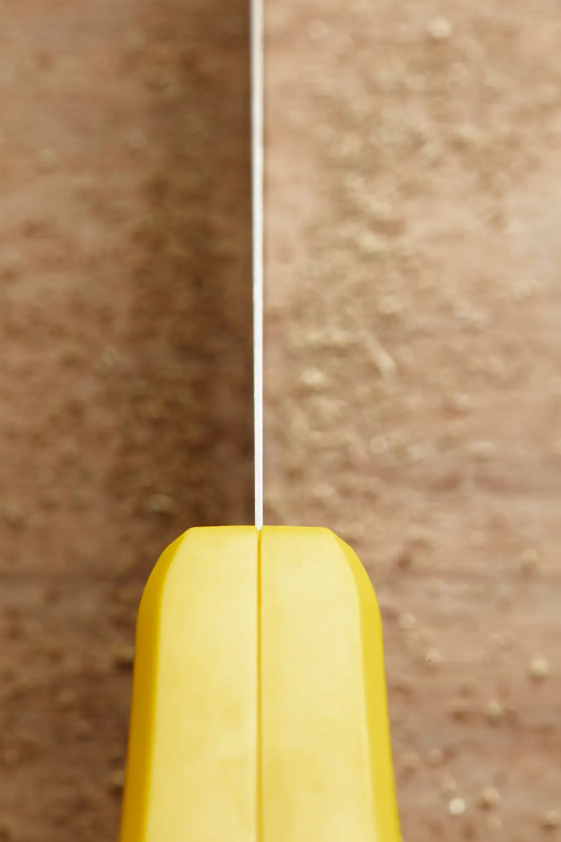 STANLEY STHT20369-1 close-up photo of yellow hand saw handle and blade on wood surface.