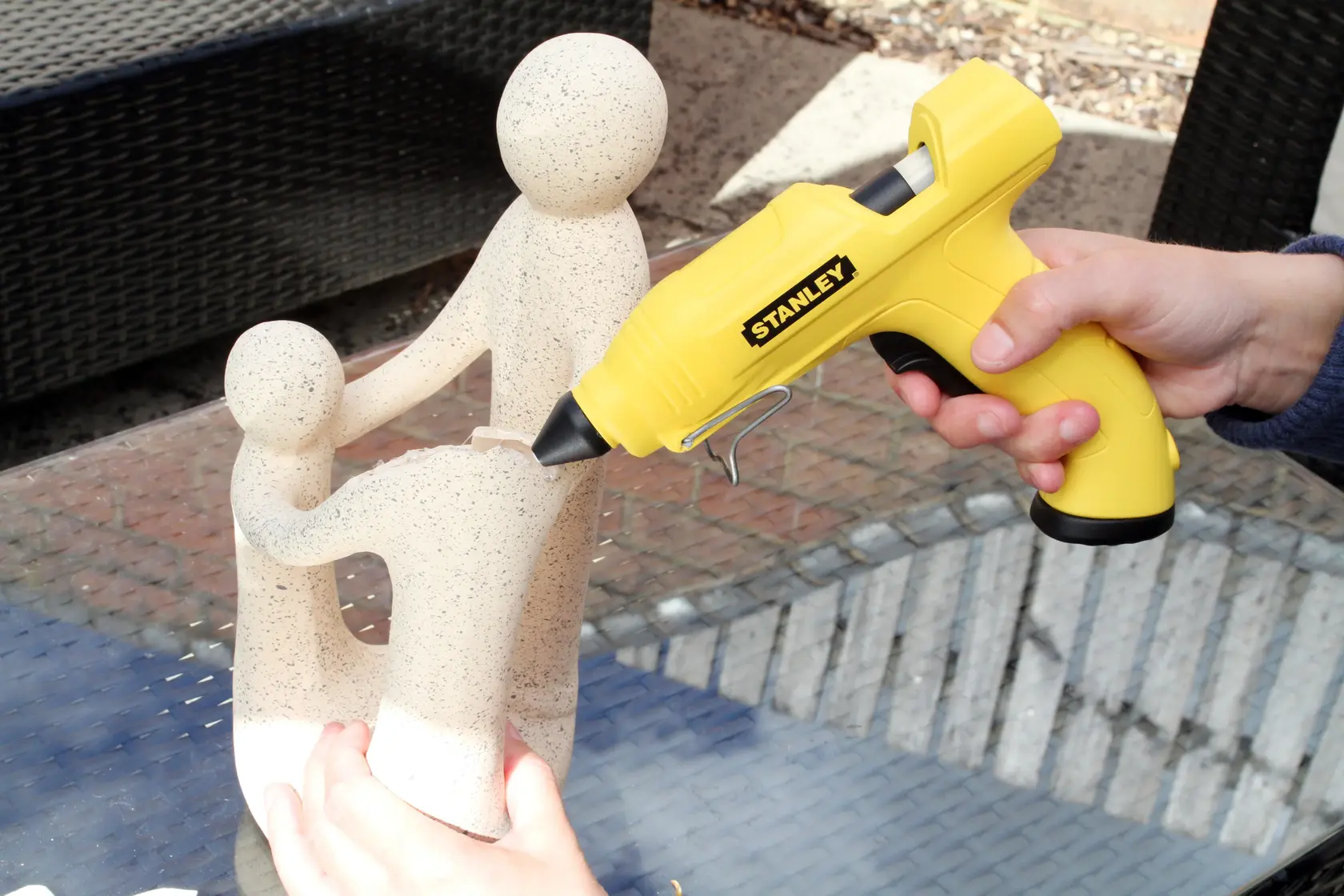 Stanley STHT6-70416 yellow glue gun used on sculpture, side angle, product photography.