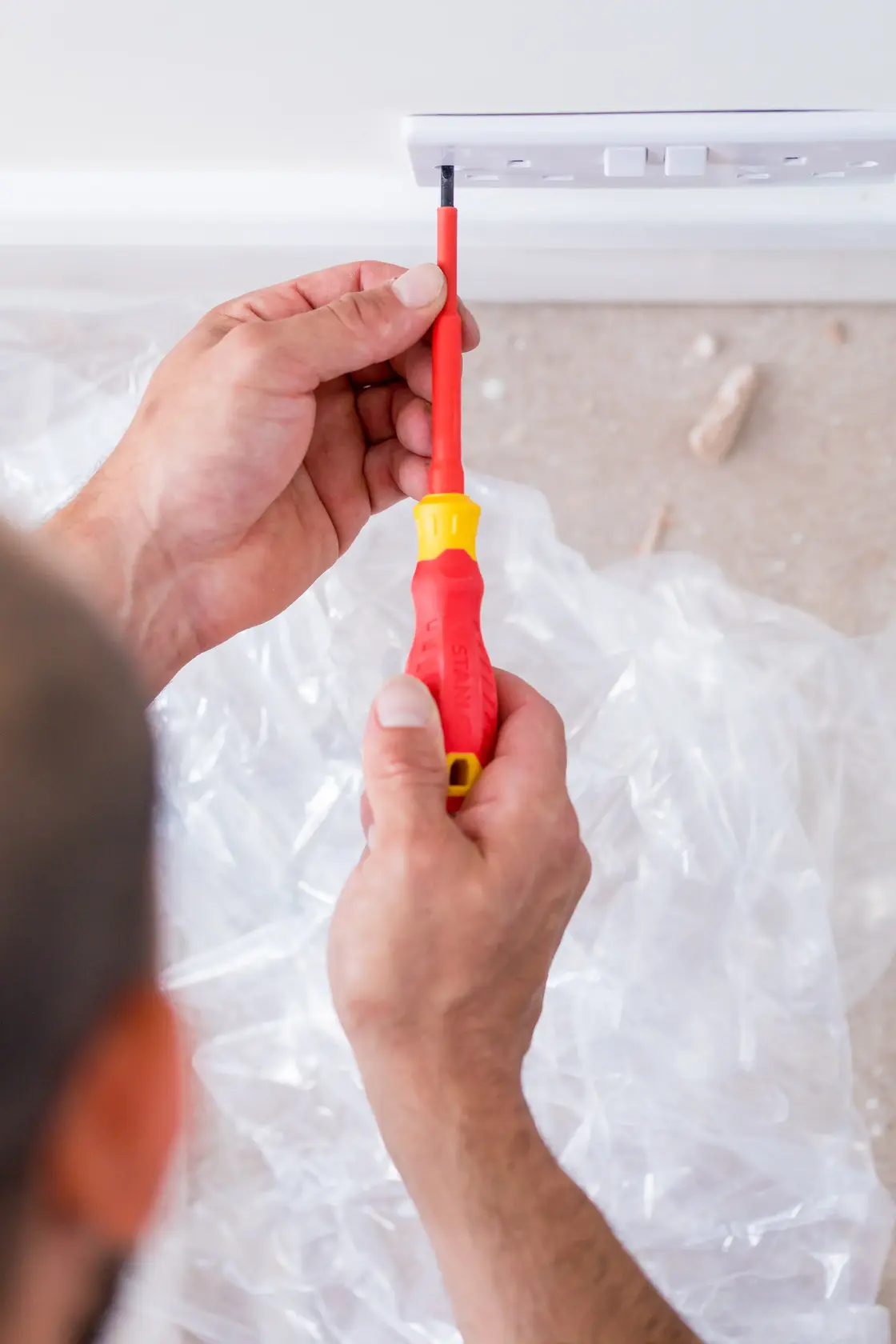 STANLEY STHT60031-0 insulated screwdriver used to install a wall socket, close-up photography.