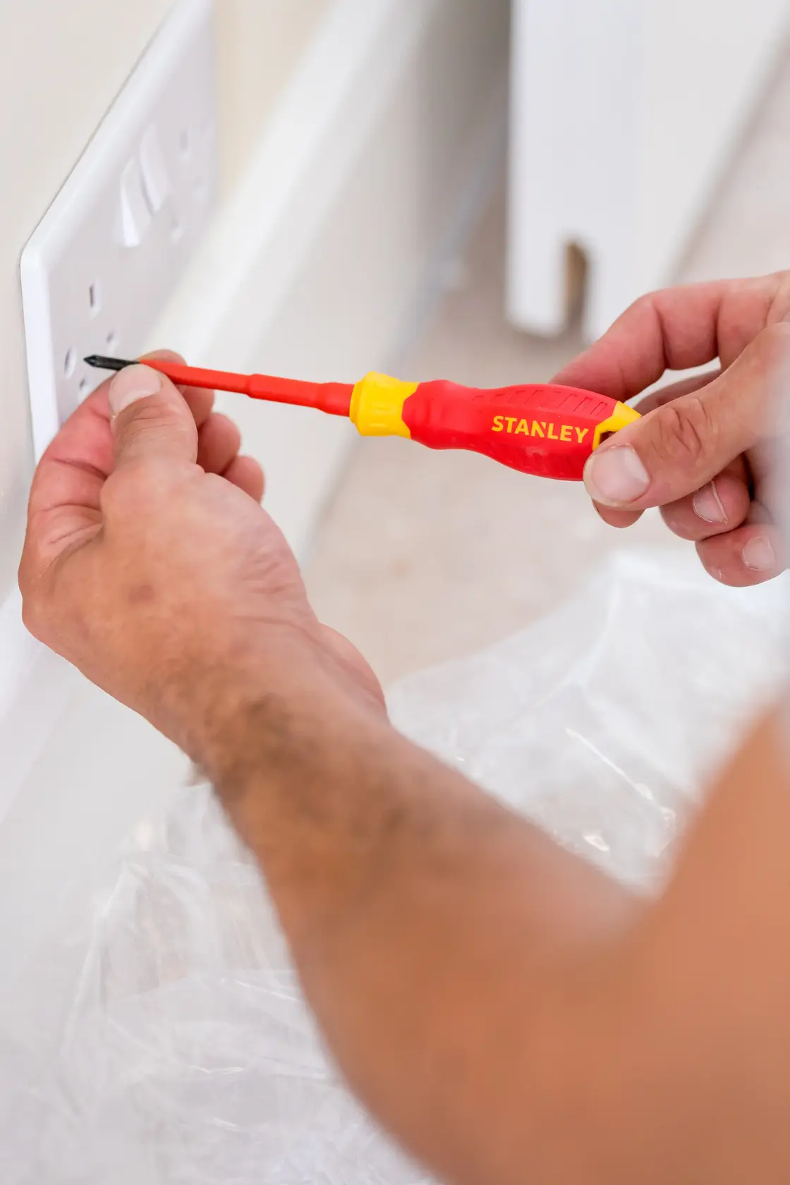 Photo of STANLEY STHT60031-0 insulated screwdriver used to fix a wall electrical outlet.