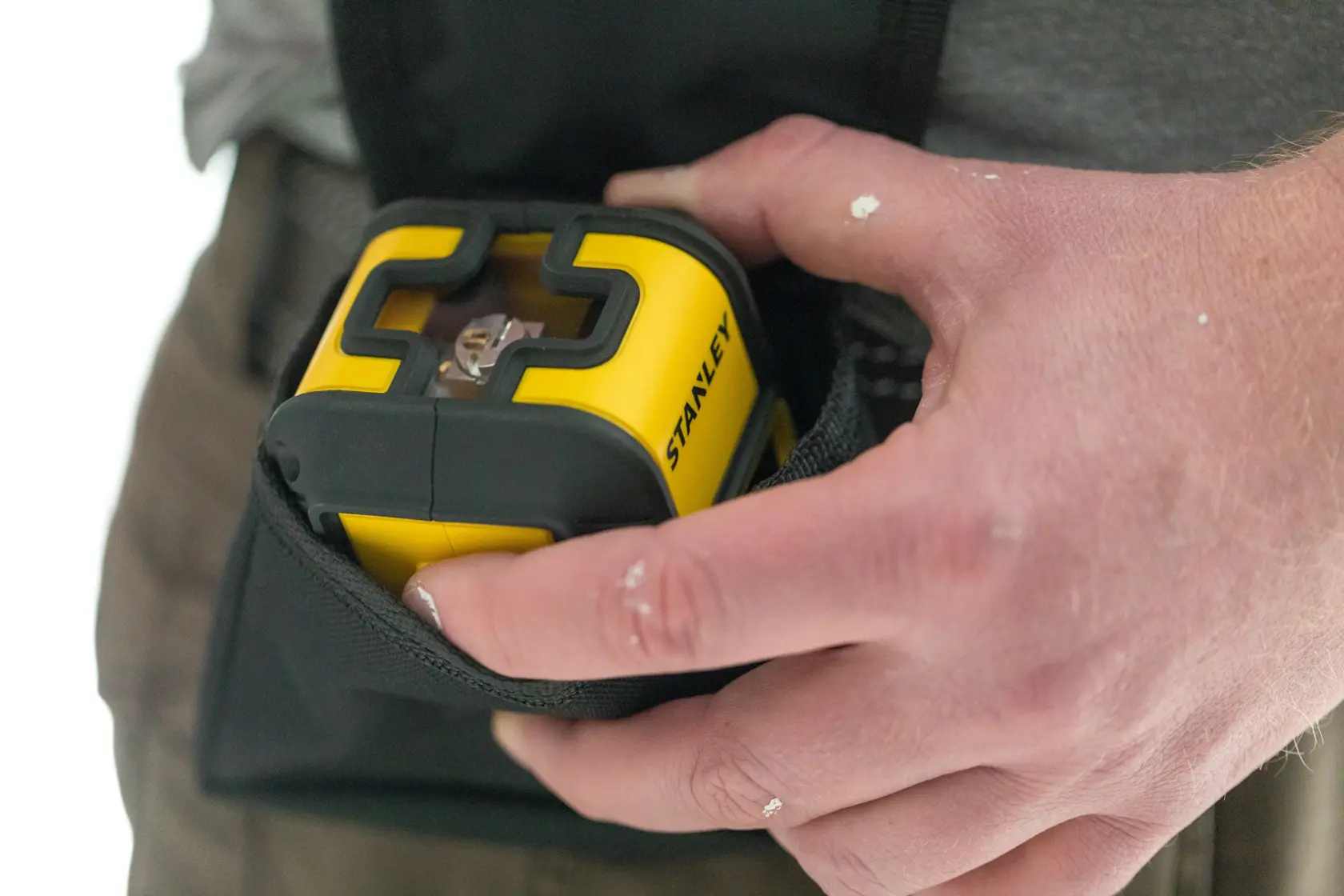Foto des gelb-schwarzen STANLEY STHT77499-1 Laser-Nivelliergeräts, das in eine Werkzeugtasche gelegt wird.