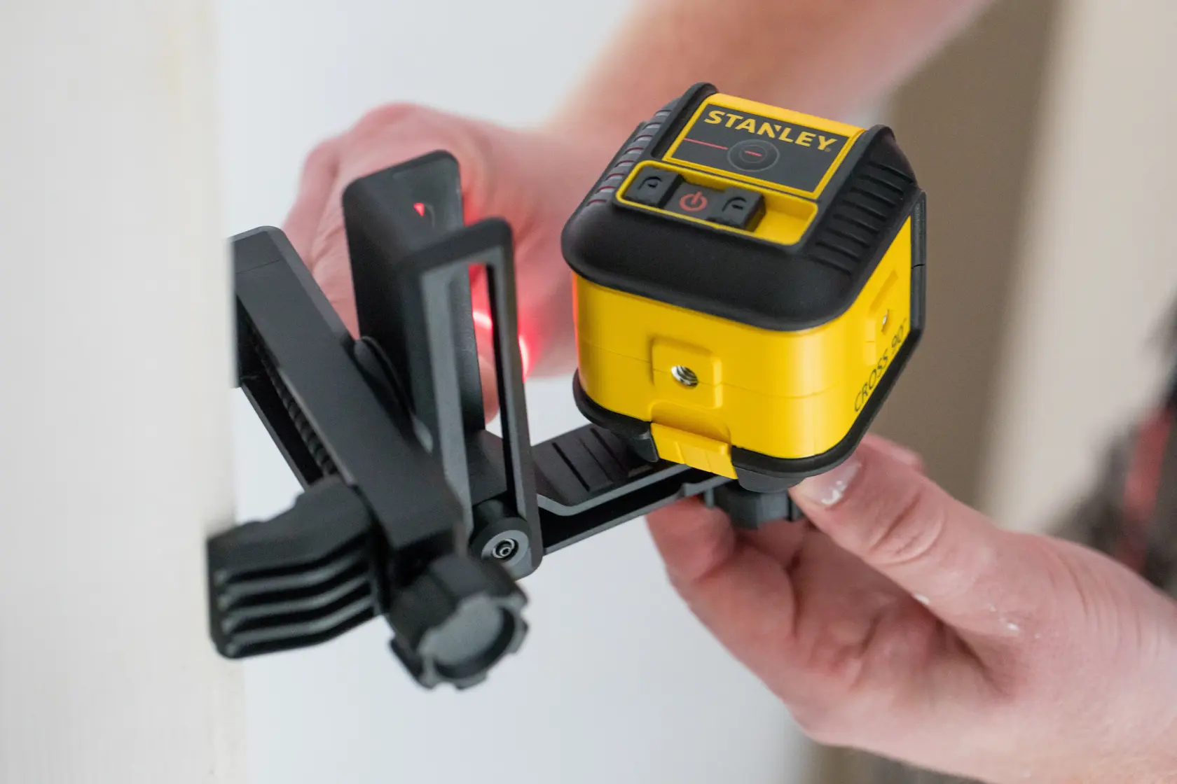STANLEY STHT77502-1 yellow and black laser level mounted on adjustable bracket, in use.
