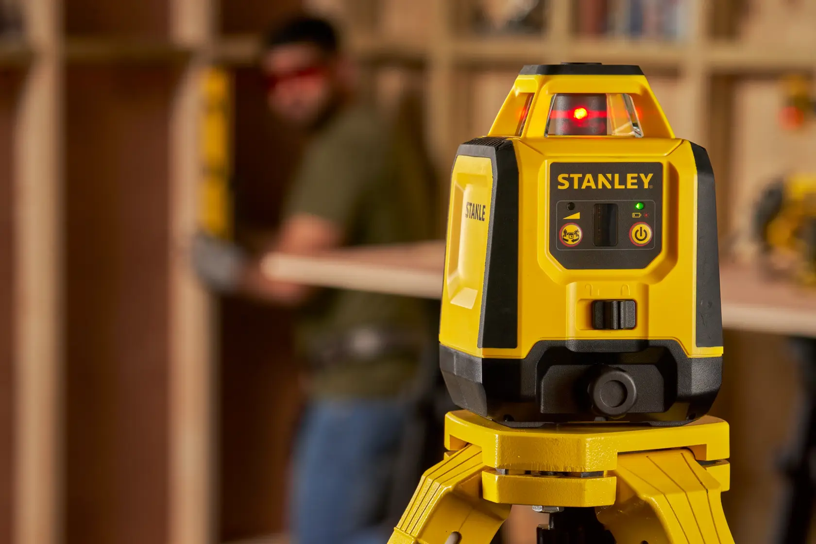Photo of STANLEY STHT77616-0 yellow laser level on tripod, used for construction alignment.
