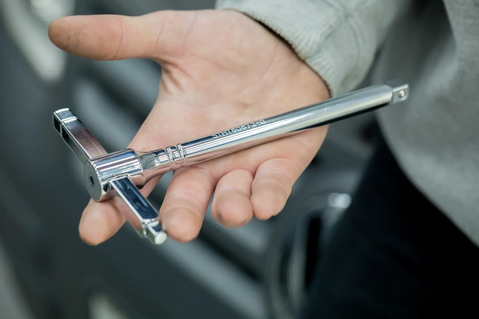 STANLEY STHT80872-0 chrome T-handle tap wrench held in hand, close-up photography.