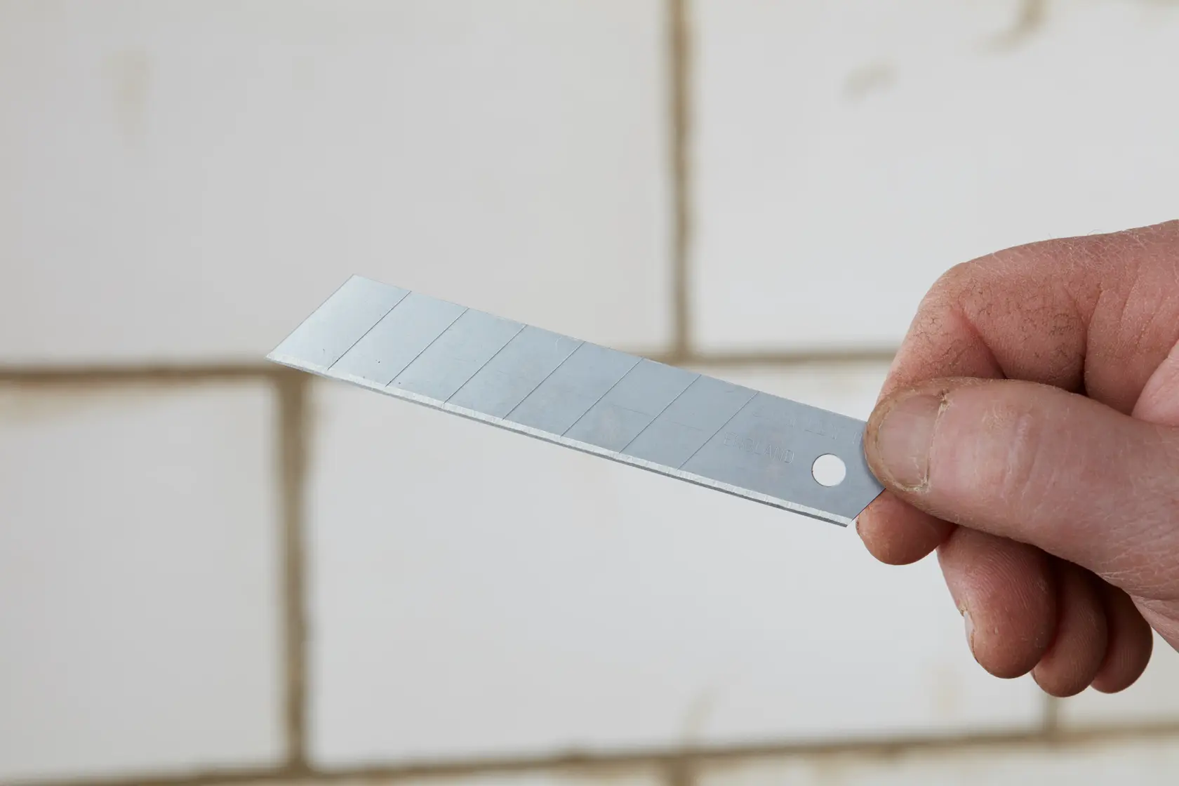 STANLEY STHT9-11301 utility snap-off blade held in hand with segmented design, silver color.