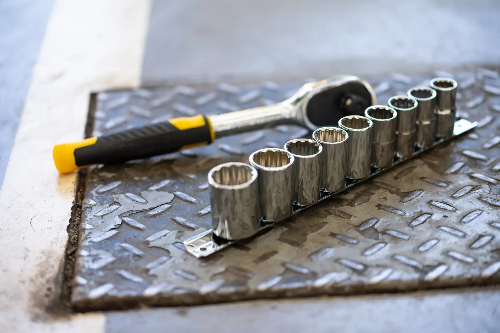 STANLEY STMT82670-0 ratchet and socket set on metal surface, yellow and black handle visible.