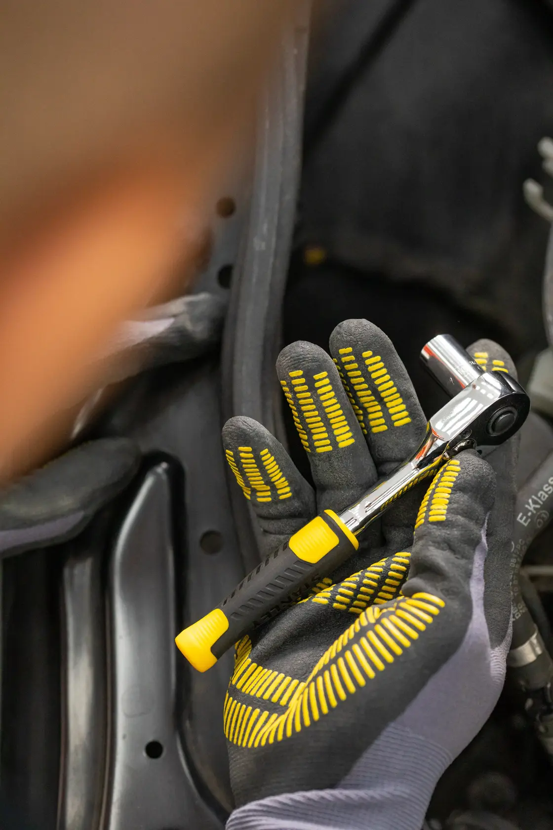 Photo of STANLEY STMT82829-1 ratchet wrench held in a gloved hand, featuring a black and yellow handle.