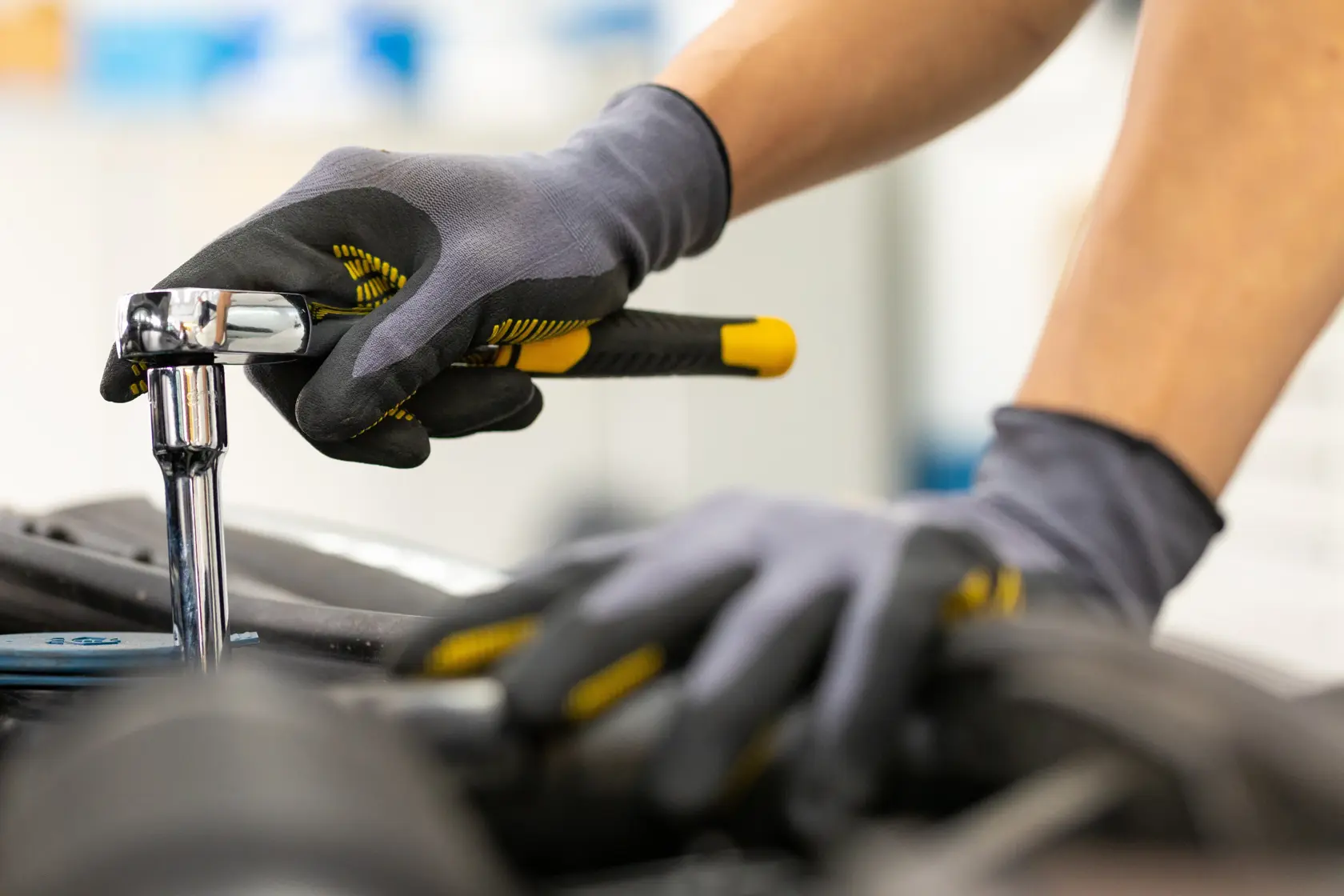 STANLEY STMT82830-1 ratchet wrench in use, close-up, black and yellow handle, mechanic gloves.