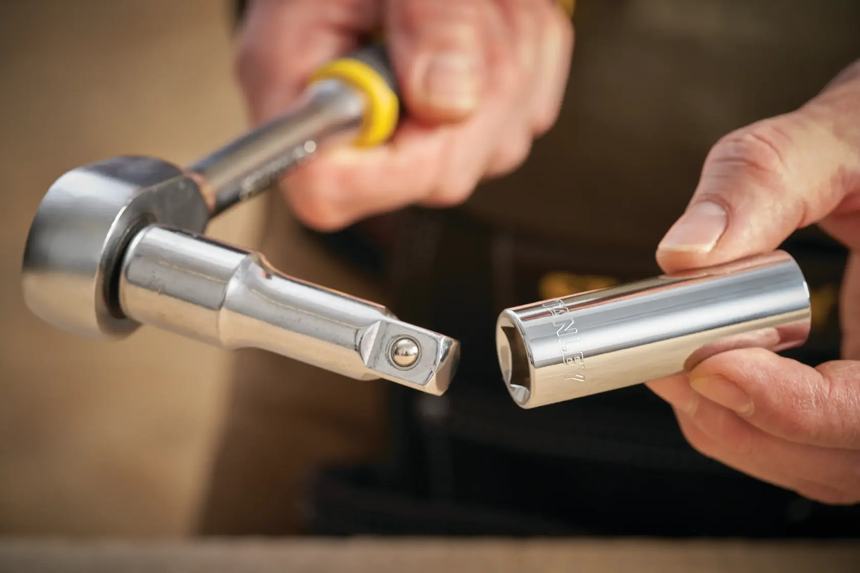 STANLEY STMT88994-0 socket wrench and chrome socket, close-up in hand, showing tool details.