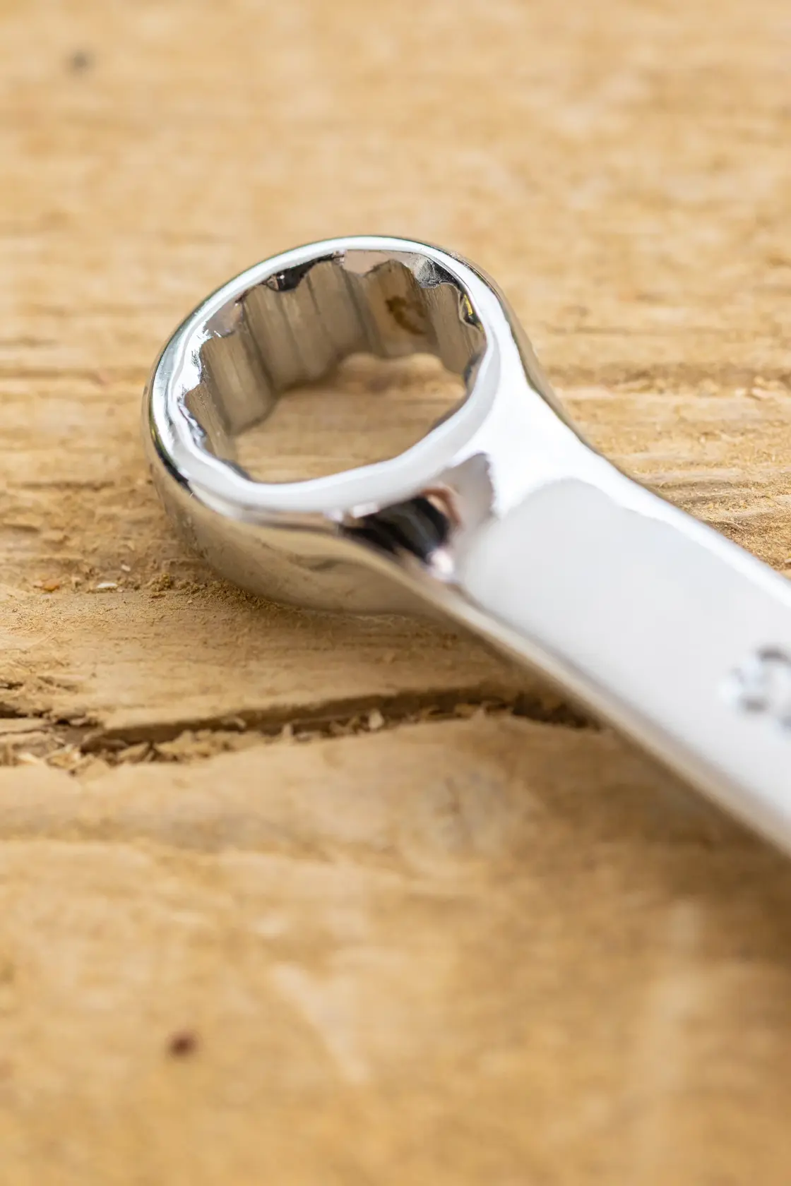 STANLEY STMT95912-0 box-end wrench close-up, silver finish on wood surface, photography.