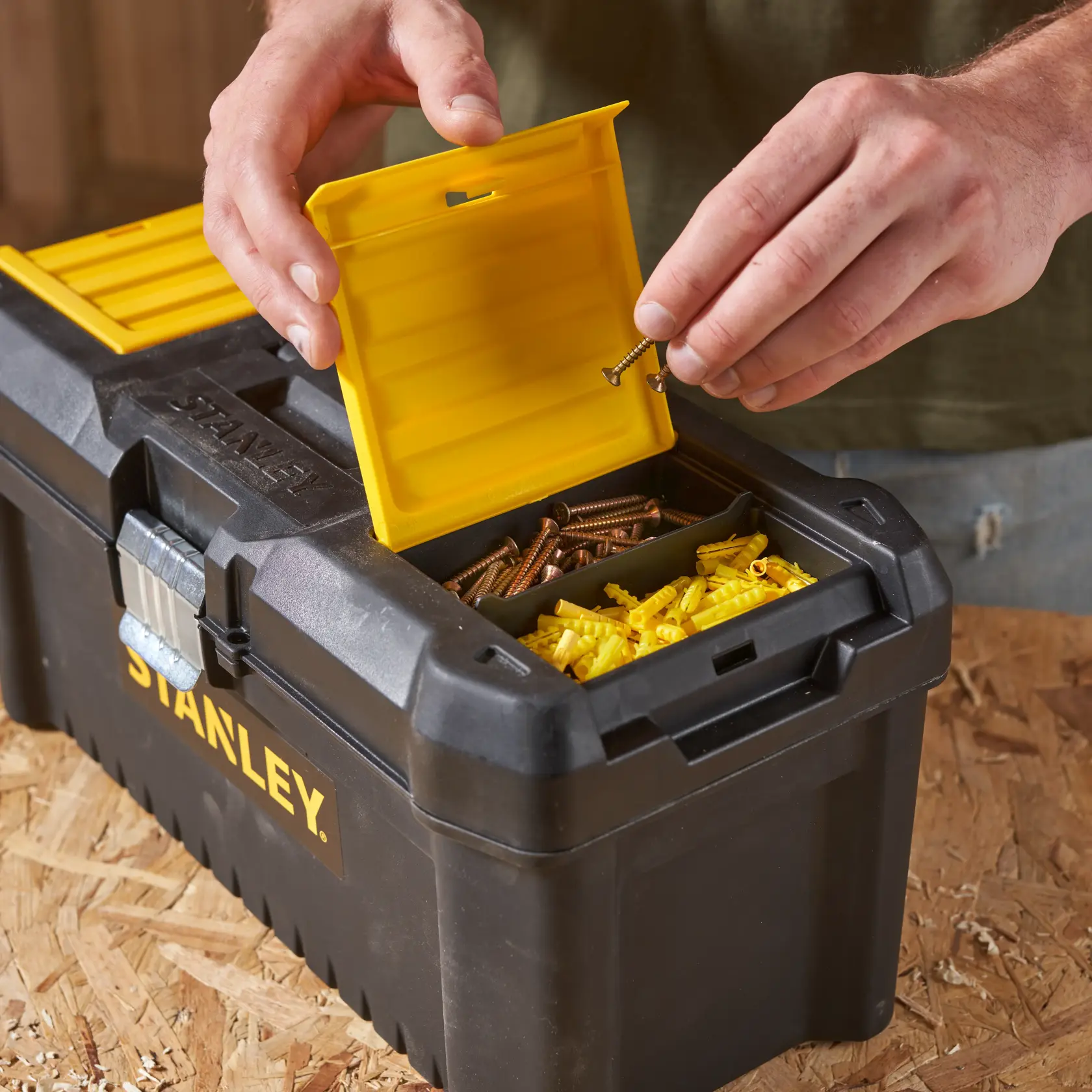 STANLEY STST1-75518-KR Werkzeugbox mit offenem gelbem Fachdeckel, Schrauben und Dübel, Nahaufnahme.