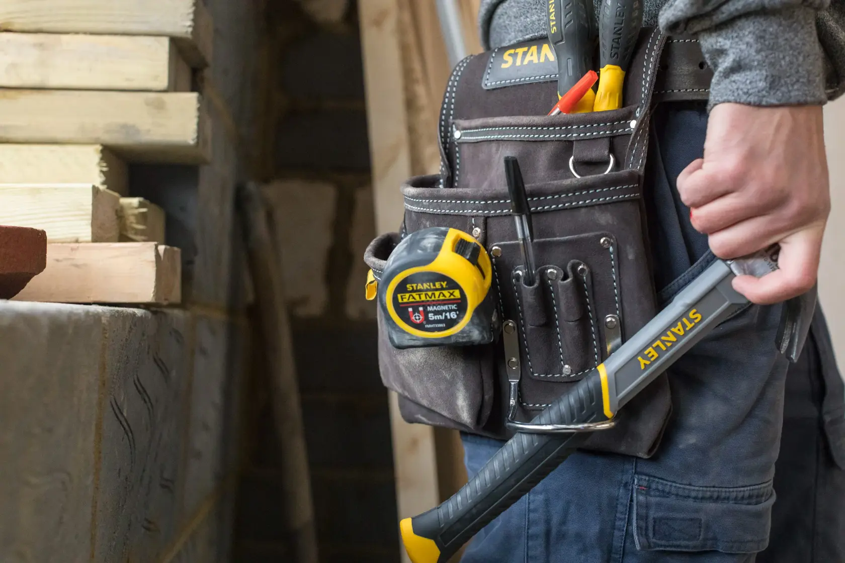 STANLEY STST1-80114 Werkzeuggürtel mit Maßband, Handwerkzeugen und Hammer auf Baustelle.