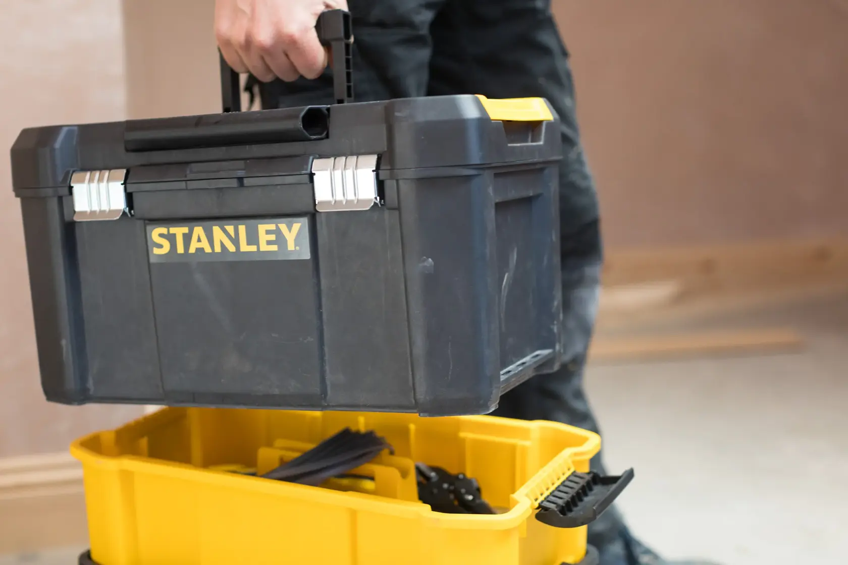 STANLEY STST1-80151 schwarzer Werkzeugkasten mit gelben Akzenten, von Hand getragen, Kategorie Fotografie.