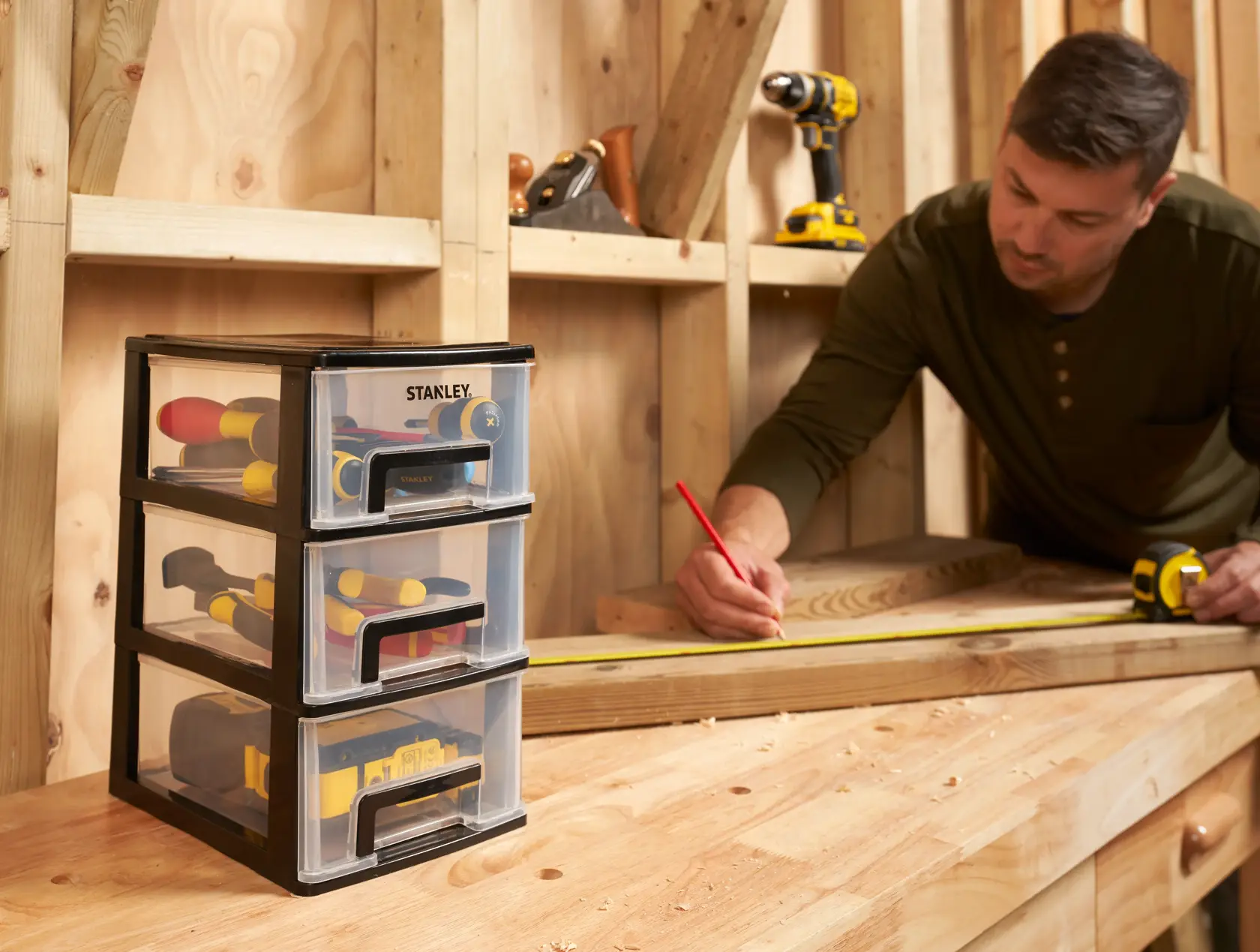 STANLEY STST40711-1 three-drawer tool organizer on workbench, filled with hand tools, photography.