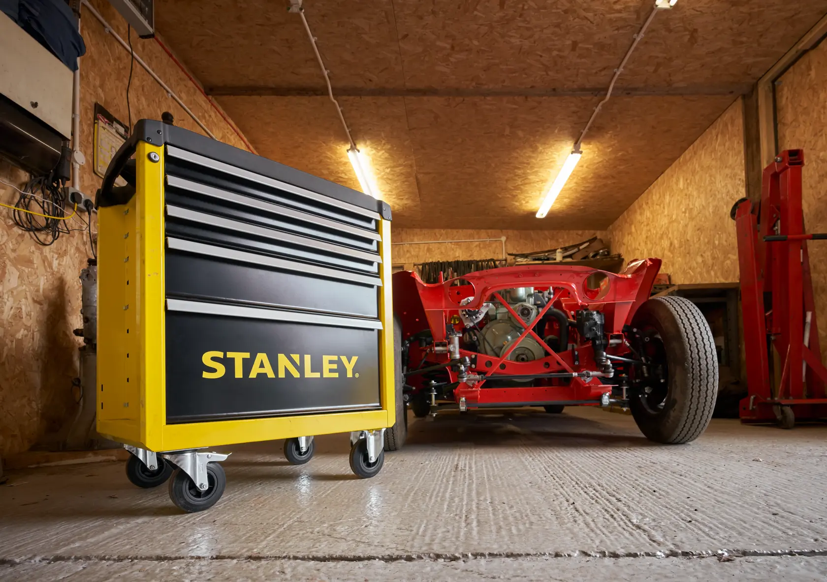Foto einer Hand, die einen gelben STANLEY STST74305-1 Werkzeugkasten mit einem Schlüssel abschließt, Nahaufnahme seitlich.