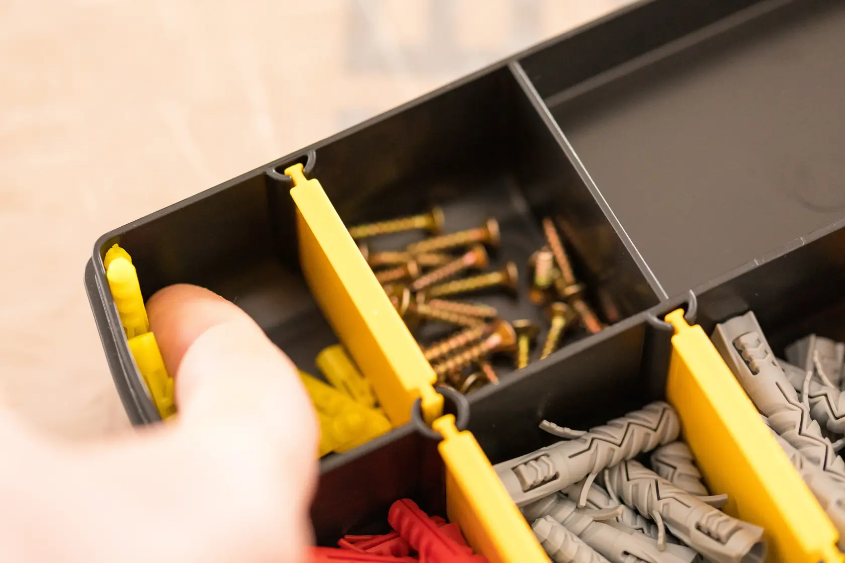 STANLEY STST81680-1 Organizerbox mit gelben Trennwänden, Schrauben und Dübel, Nahaufnahme.