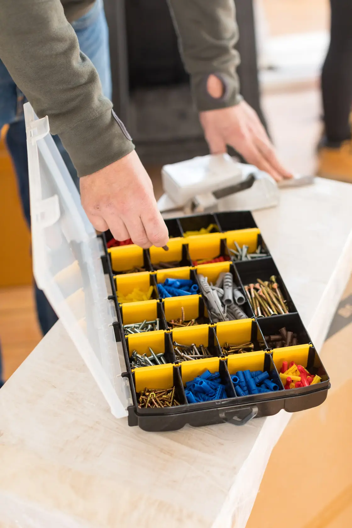 STANLEY STST81681-1 Organizer-Box mit gelben Trennwänden und verschiedenen Schrauben und Dübeln, offen auf einem Tisch.