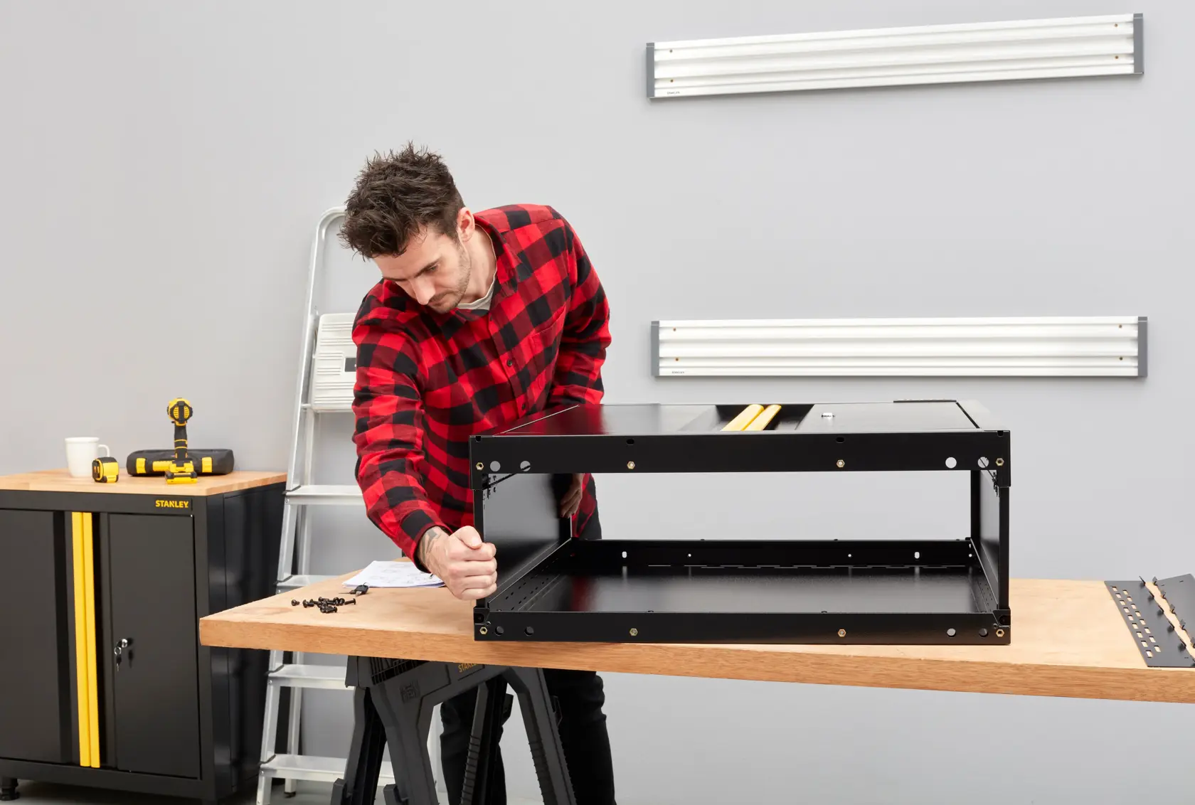 STANLEY STST97598-1 black metal cabinet assembly on wooden table in workshop, photography front angle.