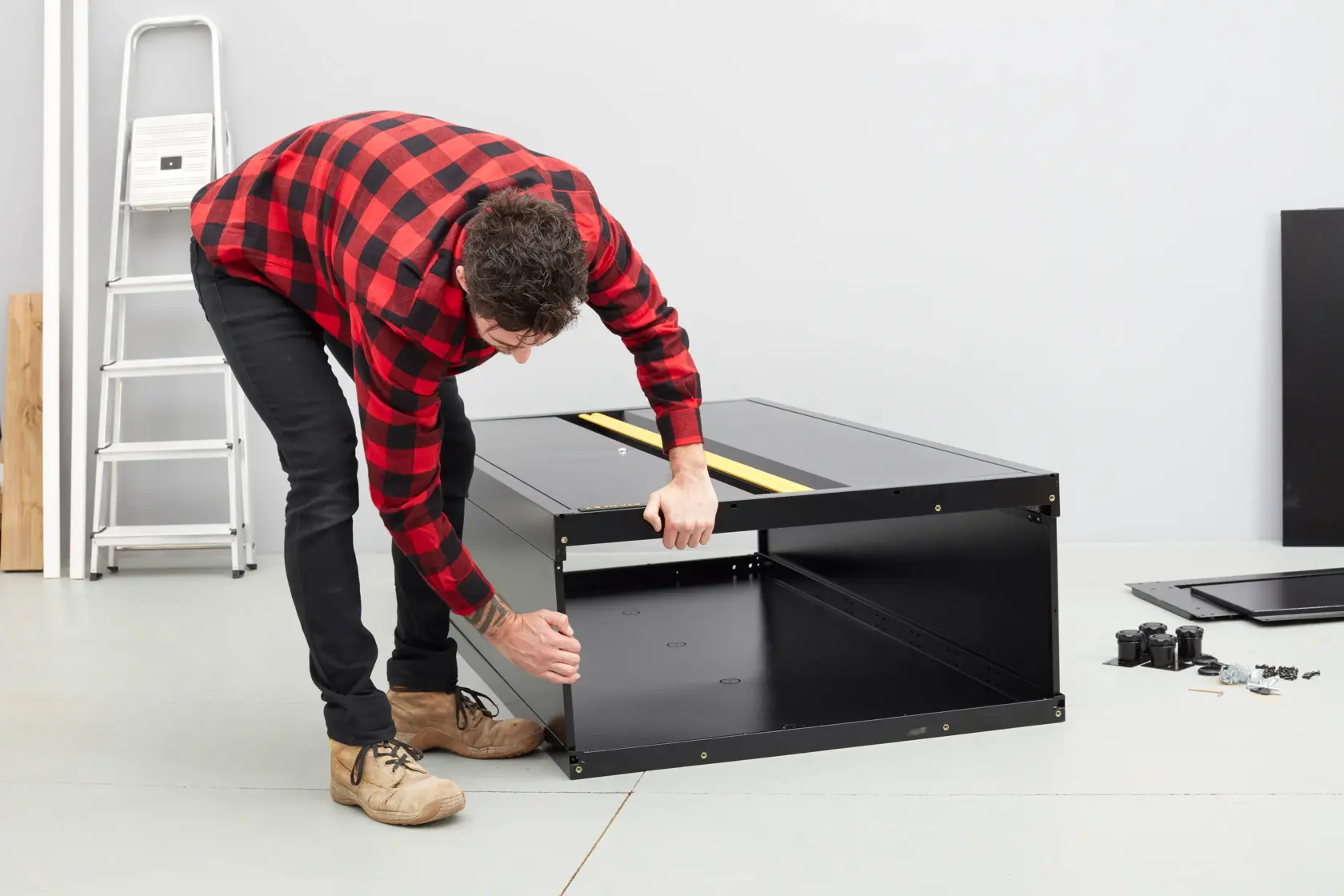 STANLEY STST97957-1 cabinet assembly in progress, black steel cabinet on floor with hardware nearby.