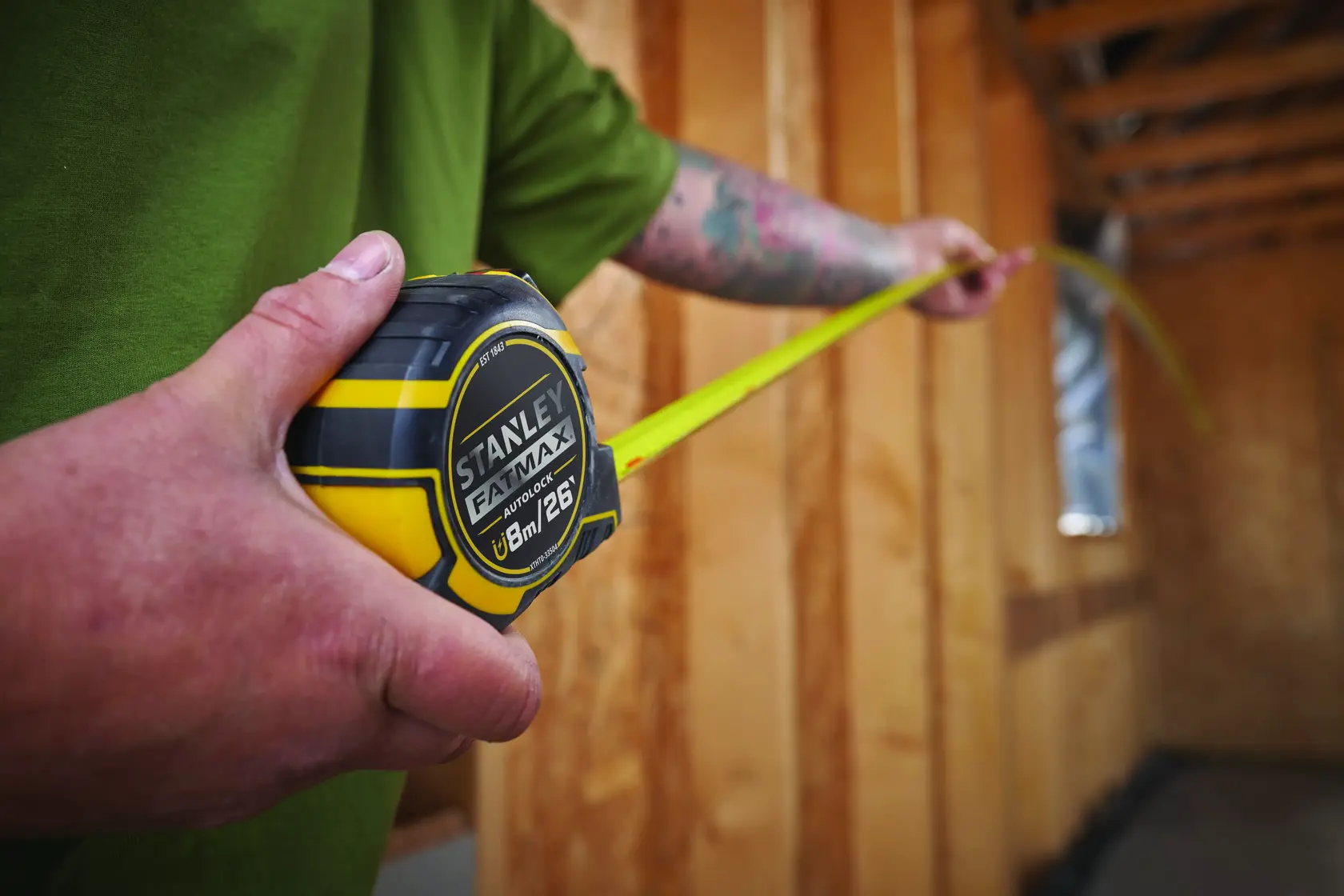 Photo of STANLEY XTHT0-33504 tape measure being used inside a wooden construction site.
